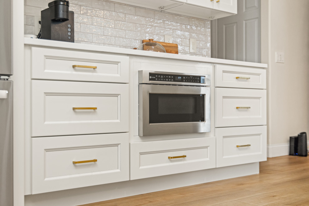 Small transitional l-shaped light wood floor and multicolored floor eat-in kitchen photo in Tampa with an undermount sink, shaker cabinets, beige cabinets, quartzite countertops, beige backsplash, porcelain backsplash, stainless steel appliances, a peninsula and white countertops