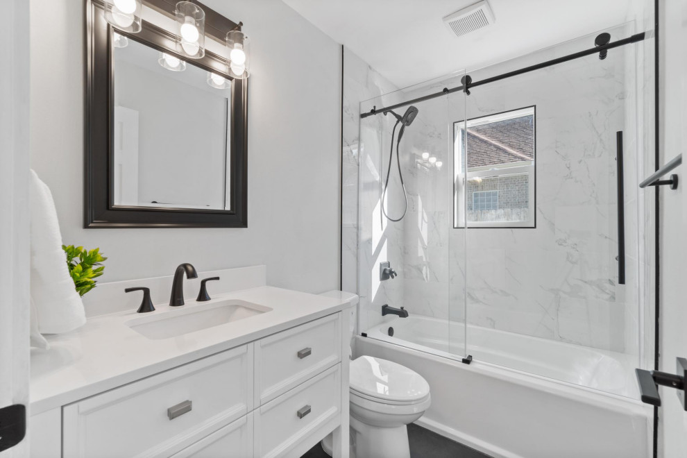 Exemple d'une salle de bain grise et noire rétro en couloir de taille moyenne avec un placard en trompe-l'oeil, des portes de placard blanches, une baignoire indépendante, un combiné douche/baignoire, WC à poser, un carrelage gris, un mur gris, un lavabo encastré, un sol noir, une cabine de douche à porte coulissante, un plan de toilette blanc, meuble simple vasque, meuble-lavabo sur pied et un plan de toilette en quartz modifié.