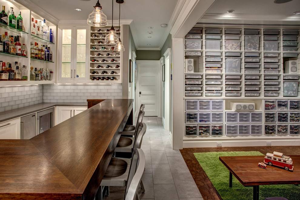 This is an example of a transitional fully buried basement in Seattle with grey walls, no fireplace and a home bar.