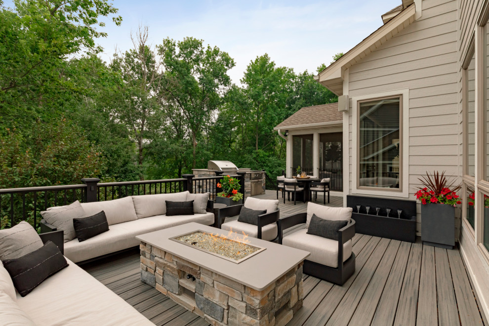 Modelo de terraza de estilo americano grande en patio trasero con cocina exterior y barandilla de metal
