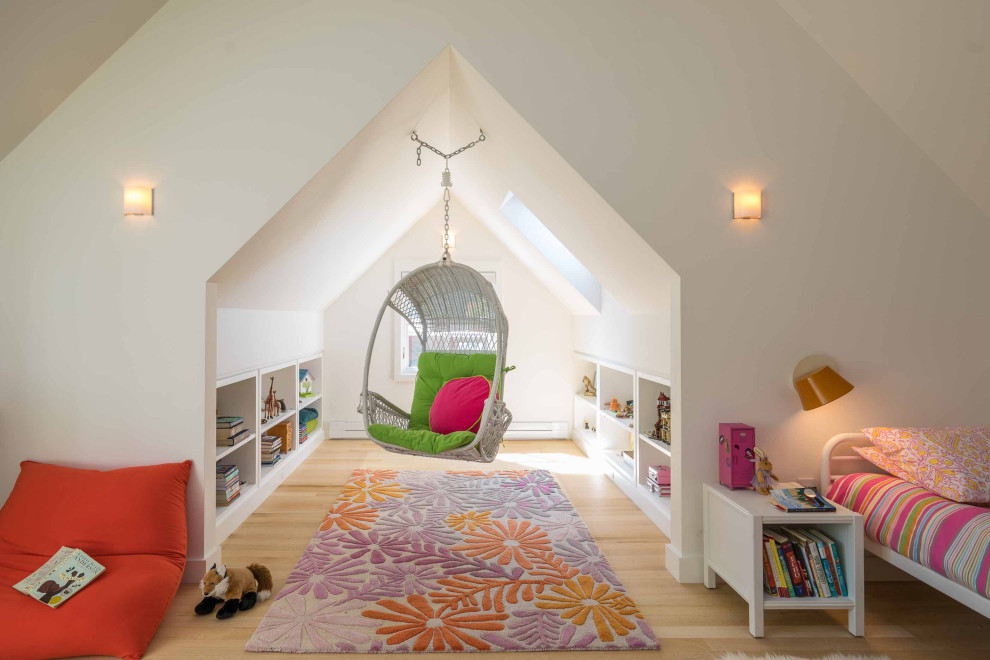 This is an example of a contemporary kids' bedroom for girls in Boston with white walls, light hardwood floors, beige floor and vaulted.