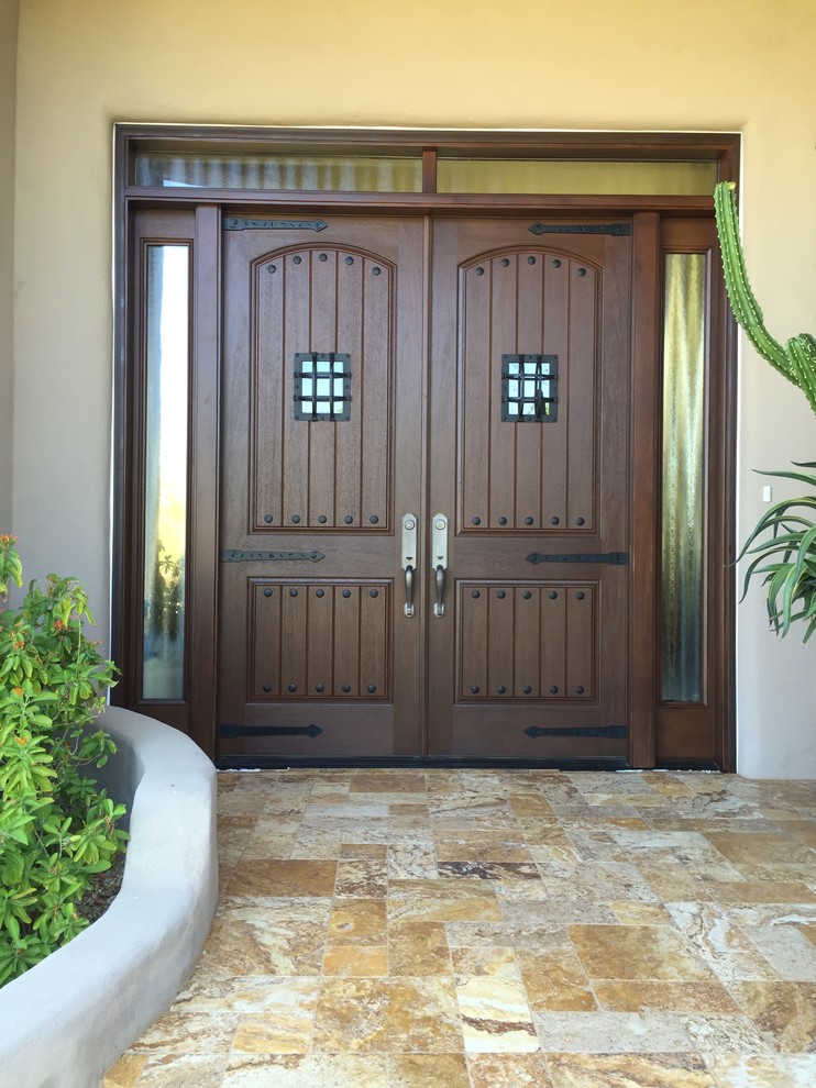 This is an example of a large front door in Phoenix with beige walls, granite floors, a double front door and a dark wood front door.