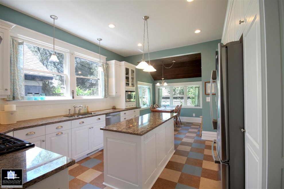 Mid-sized traditional u-shaped eat-in kitchen in Salt Lake City with a double-bowl sink, raised-panel cabinets, white cabinets, granite benchtops, white splashback, subway tile splashback, stainless steel appliances, cork floors and with island.