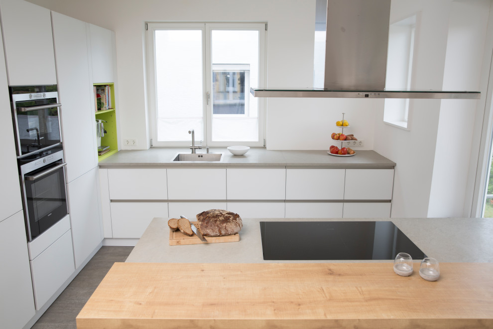 Zweizeilige, Mittelgroße Moderne Wohnküche mit Kalkstein-Arbeitsplatte, Halbinsel und grauer Arbeitsplatte in Stuttgart