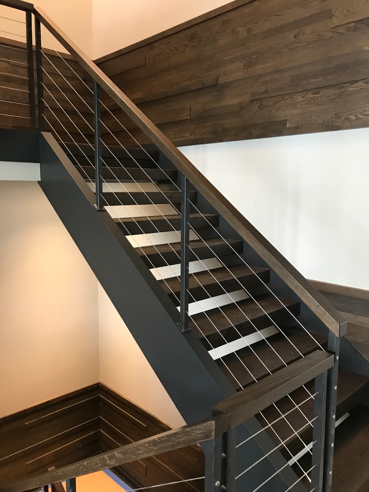 Design ideas for an expansive modern wood l-shaped staircase in Chicago with metal risers and cable railing.
