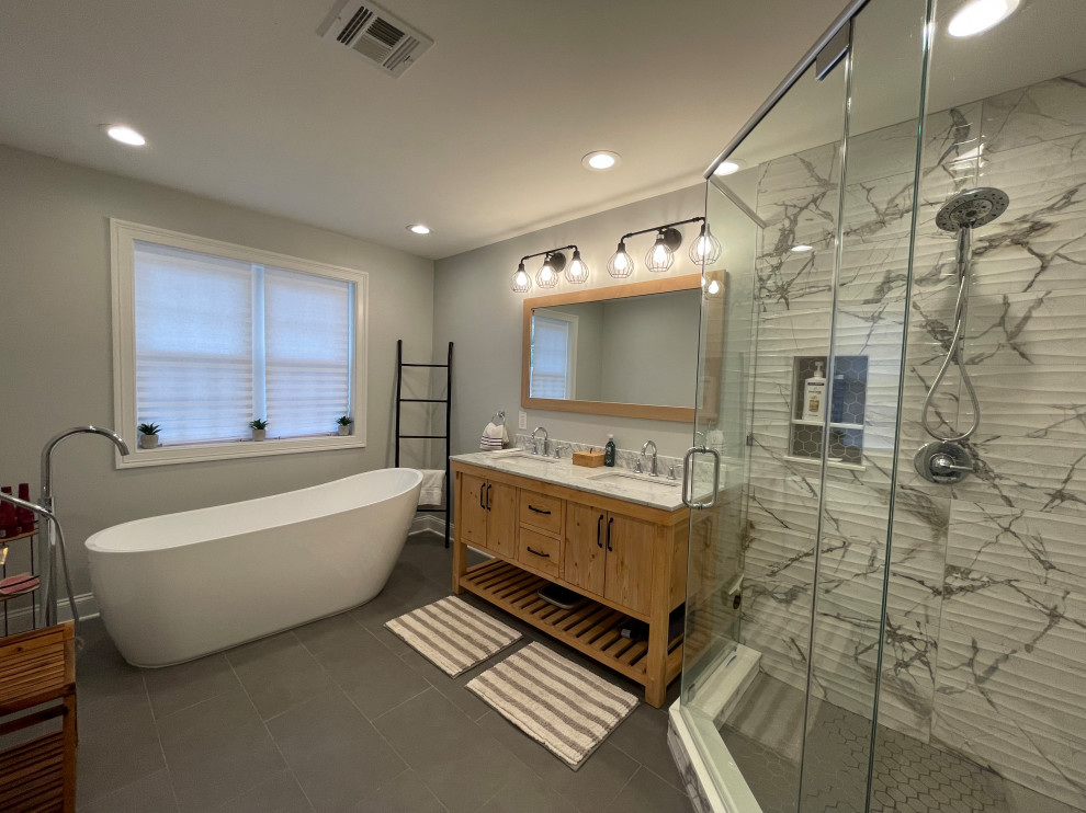 Bild på ett mellanstort vintage vit vitt en-suite badrum, med skåp i ljust trä, ett fristående badkar, en hörndusch, vit kakel, porslinskakel, grå väggar, klinkergolv i porslin, ett undermonterad handfat, marmorbänkskiva, grått golv och dusch med gångjärnsdörr