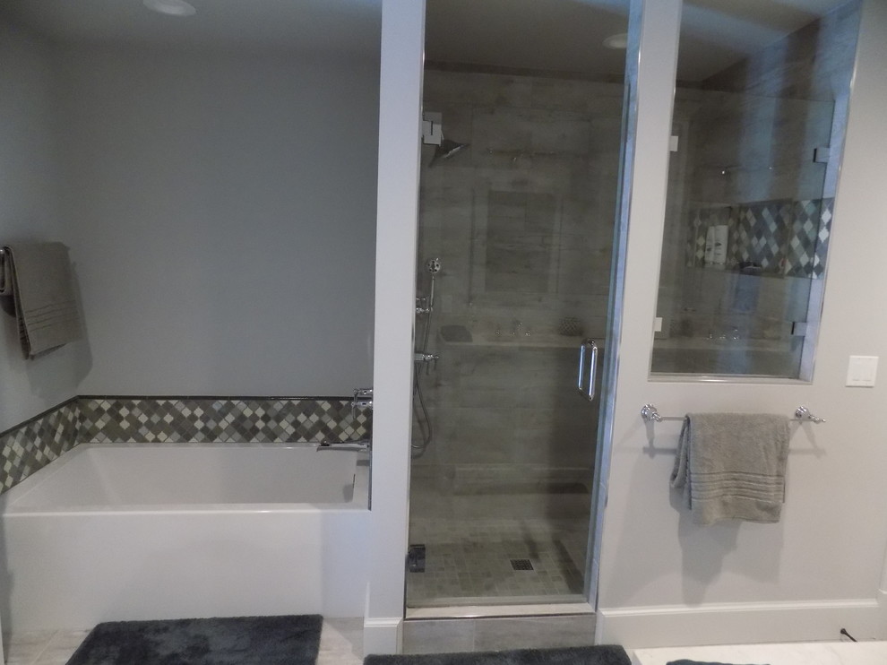 Example of a mid-sized transitional master gray tile and white tile laminate floor alcove bathtub design with recessed-panel cabinets, white cabinets, gray walls and an undermount sink