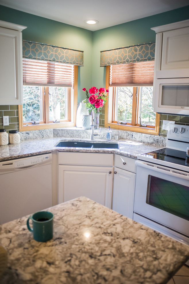 Inspiration for a small transitional u-shaped ceramic tile eat-in kitchen remodel with a drop-in sink, raised-panel cabinets, white cabinets, granite countertops, brown backsplash, porcelain backsplash, white appliances and an island