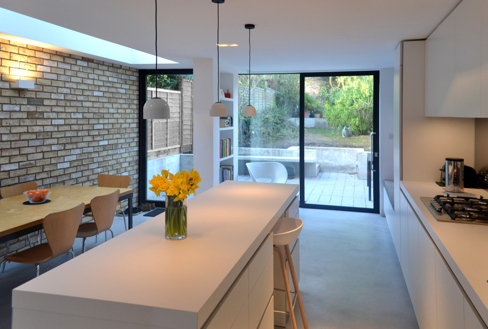 Design ideas for a contemporary kitchen in London with stainless steel appliances and concrete floors.