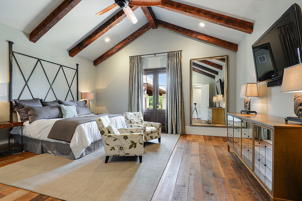 Photo of a large transitional master bedroom in New Orleans with light hardwood floors.