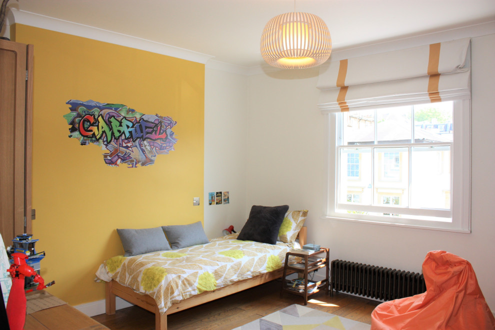 Idee per una grande cameretta per bambini contemporanea con pareti gialle, pavimento in legno massello medio e soffitto a cassettoni