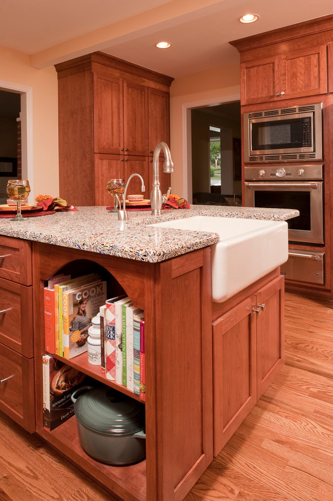 Large transitional kitchen in Nashville with an undermount sink, shaker cabinets, medium wood cabinets, recycled glass benchtops, beige splashback, subway tile splashback, stainless steel appliances, medium hardwood floors and with island.