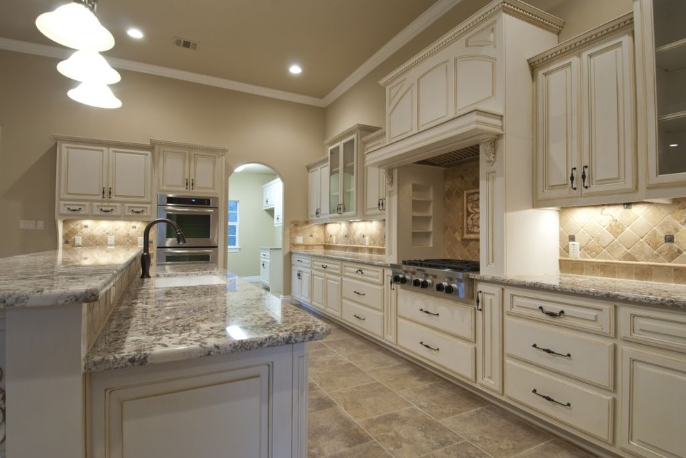 Inspiration for a traditional u-shaped eat-in kitchen in Austin with an undermount sink, raised-panel cabinets, white cabinets, granite benchtops, beige splashback, stone tile splashback and stainless steel appliances.