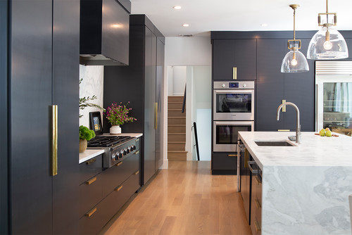 Sleek kitchen with dark RTA cabinets and a marble island—visual cue for shimming base cabinets to the level line on a sloped floor, with support under front toe-kicks and rear rails