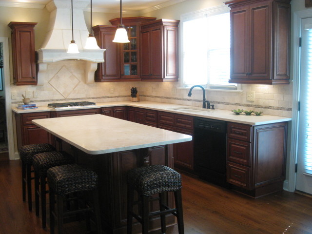 Enclosed kitchen - mid-sized transitional l-shaped dark wood floor and brown floor enclosed kitchen idea in Raleigh with an undermount sink, raised-panel cabinets, dark wood cabinets, laminate countertops, beige backsplash, ceramic backsplash, stainless steel appliances, an island and white countertops