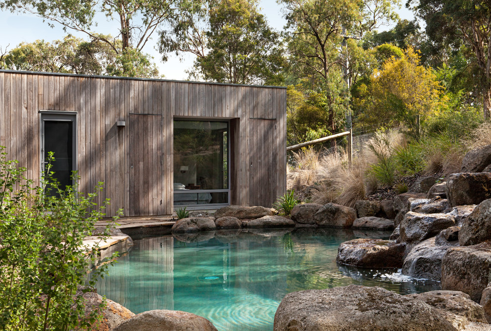 This is an example of a country backyard garden in Melbourne with a water feature.