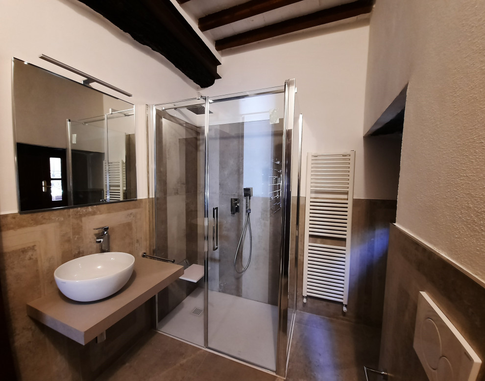 Inredning av ett mellanstort grå grått badrum med dusch, med en kantlös dusch, en vägghängd toalettstol, porslinskakel, vita väggar, klinkergolv i porslin, ett fristående handfat, grått golv och dusch med gångjärnsdörr