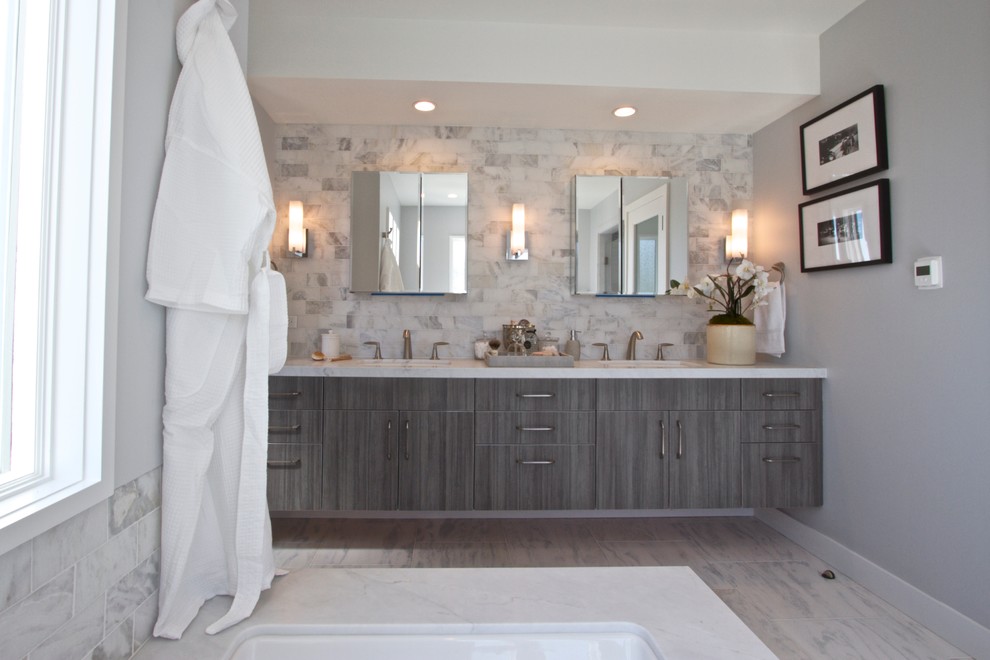 Drop-in bathtub - mid-sized transitional master gray tile, white tile and subway tile marble floor drop-in bathtub idea in Orange County with flat-panel cabinets, gray cabinets, a two-piece toilet, gray walls, an undermount sink and marble countertops