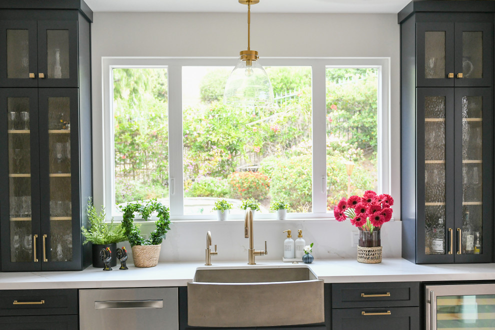 Example of a large medium tone wood floor and brown floor kitchen design in San Diego with a farmhouse sink, shaker cabinets, light wood cabinets, quartz countertops, blue backsplash, terra-cotta backsplash, paneled appliances, an island and white countertops