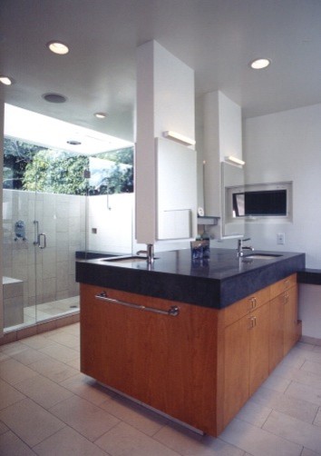 Mid-sized contemporary master bathroom in Los Angeles with flat-panel cabinets, medium wood cabinets, an alcove shower, white walls, porcelain floors, an undermount sink and soapstone benchtops.