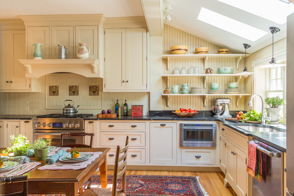 Eat-in kitchen - mid-sized traditional l-shaped medium tone wood floor eat-in kitchen idea in Boston with an undermount sink, beaded inset cabinets and stainless steel appliances