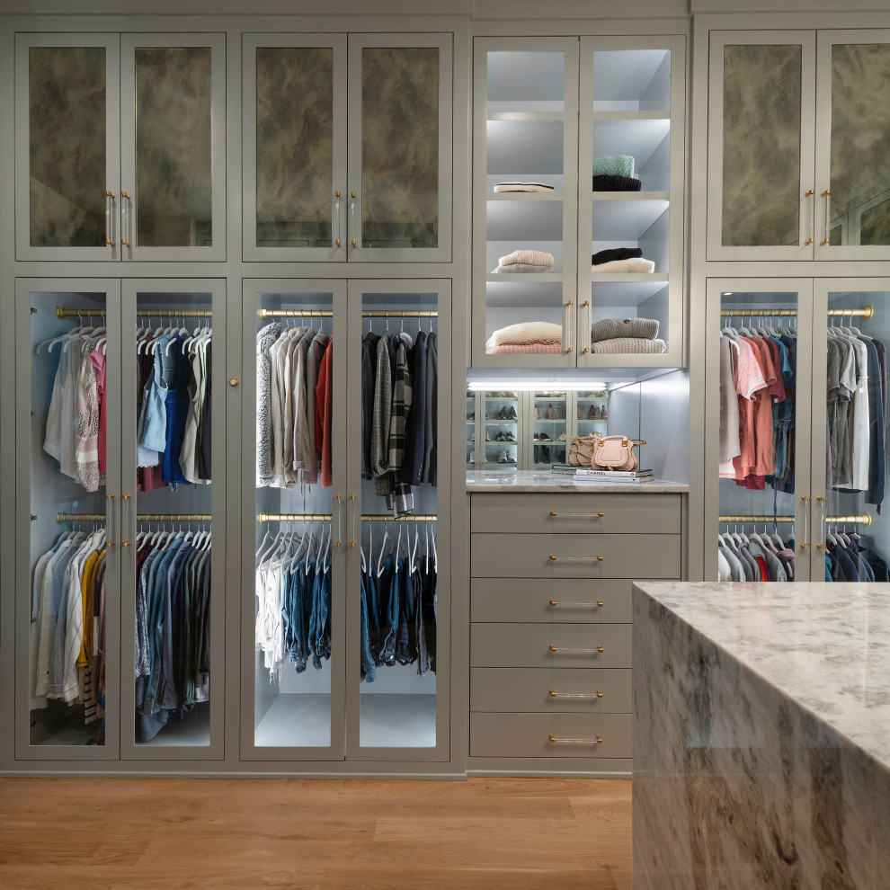Diseño de armario vestidor unisex actual grande con armarios estilo shaker, puertas de armario grises, suelo de madera clara y suelo beige