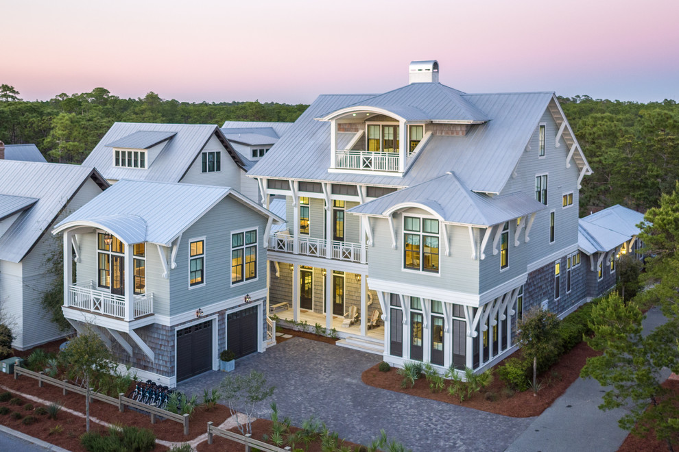 Design ideas for an expansive beach style three-storey townhouse exterior in Jacksonville with a metal roof.