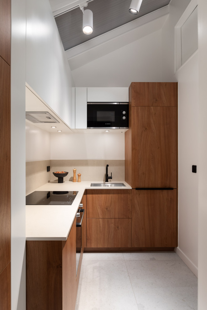Modern inredning av ett stort vit linjärt vitt kök med öppen planlösning, med en köksö, en undermonterad diskho, stänkskydd i trä, ljust trägolv och brunt golv