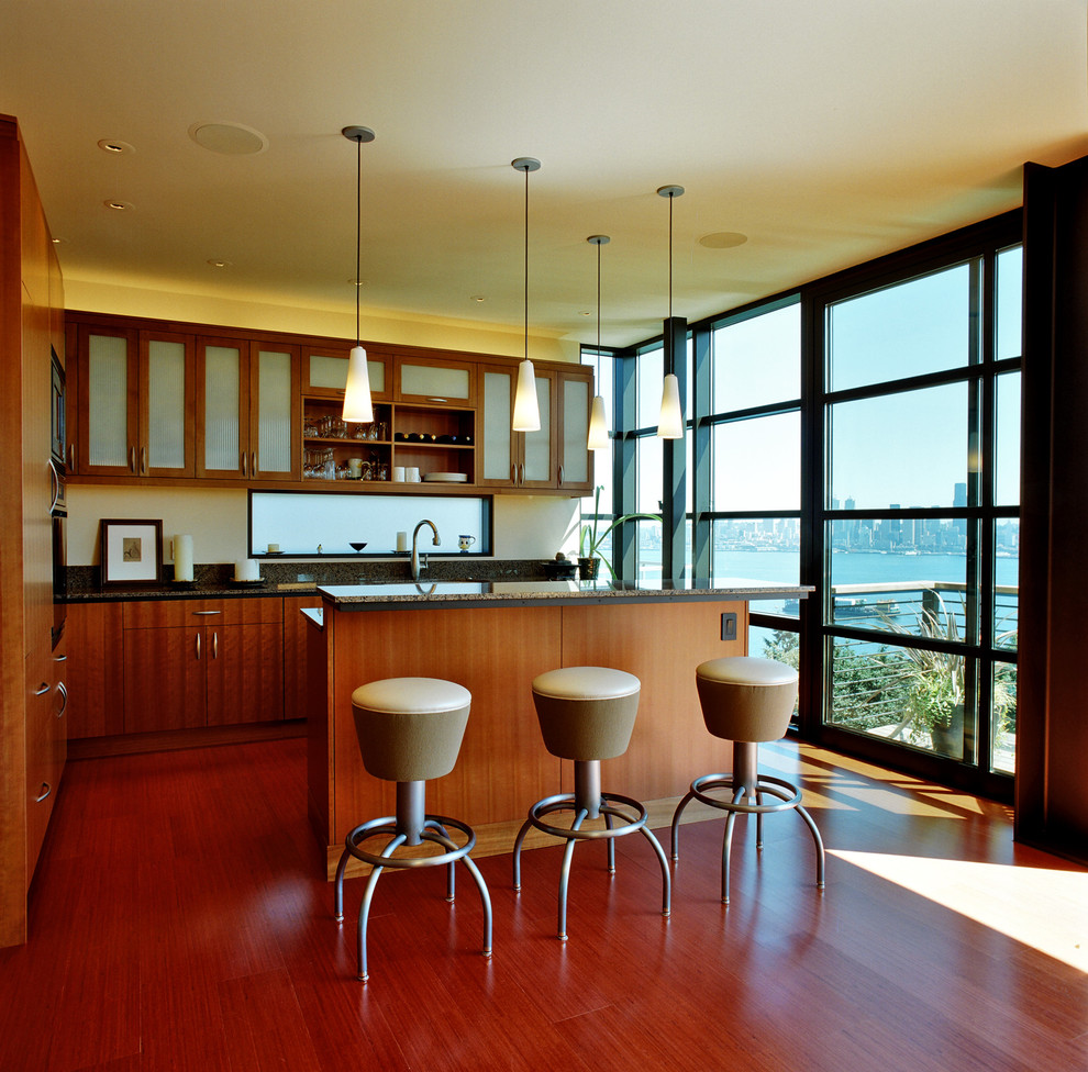 Photo of a contemporary l-shaped kitchen in Seattle with granite benchtops, glass-front cabinets and dark wood cabinets.