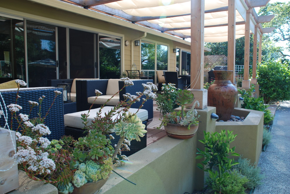 Photo of a large mediterranean backyard deck in San Francisco with a water feature and a pergola.