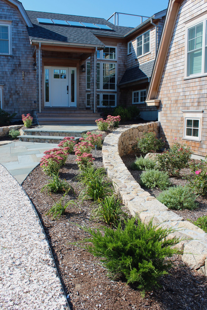 Photo of an expansive beach style full sun garden for summer in Boston with natural stone pavers.