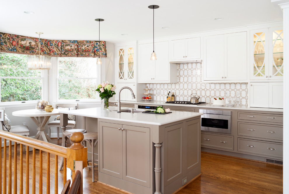 Inspiration for a mid-sized transitional l-shaped eat-in kitchen in DC Metro with white cabinets, white splashback, stainless steel appliances and with island.