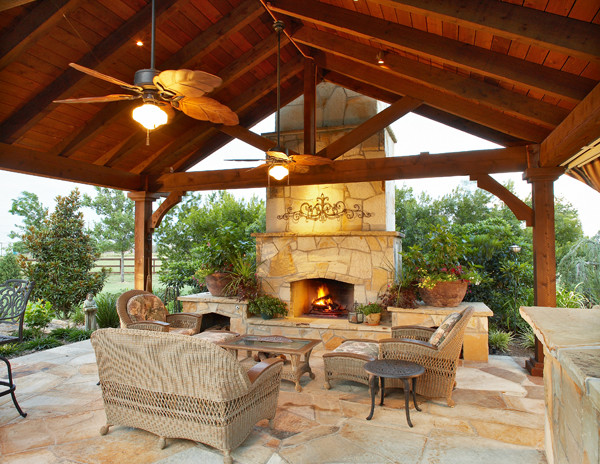 Photo of a traditional backyard patio in Dallas with a fire feature, natural stone pavers and a pergola.