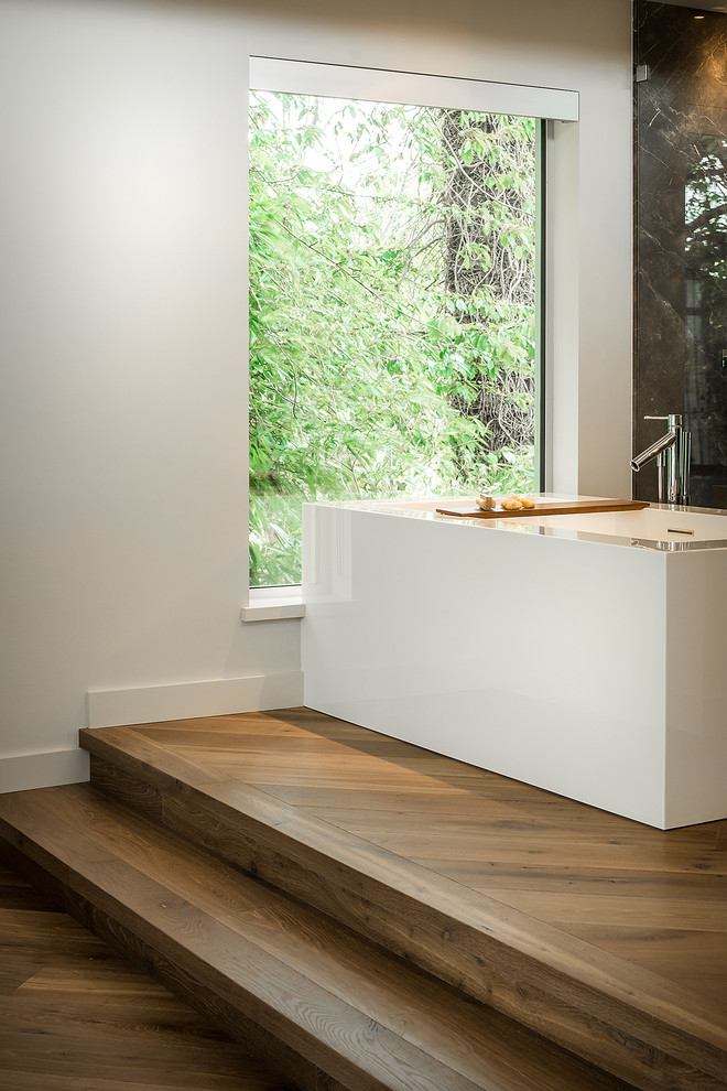 This is an example of a large contemporary master bathroom in Vancouver with a trough sink, flat-panel cabinets, dark wood cabinets, a freestanding tub, a curbless shower, a one-piece toilet and white walls.