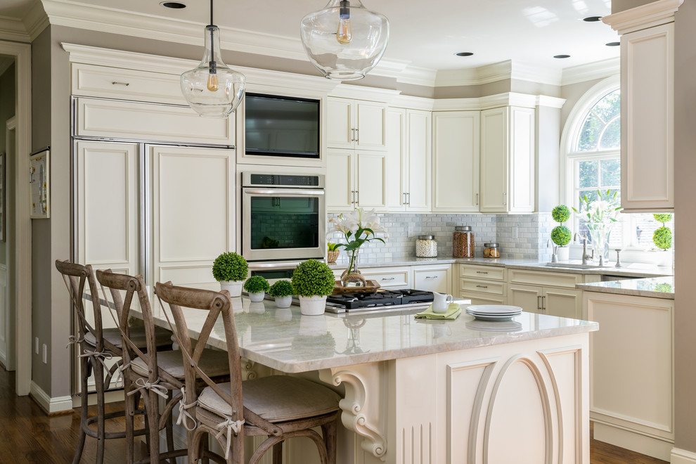 Design ideas for a mid-sized traditional u-shaped kitchen in St Louis with white cabinets, quartzite benchtops, grey splashback, marble splashback, stainless steel appliances, with island, an undermount sink, recessed-panel cabinets, dark hardwood floors and brown floor.