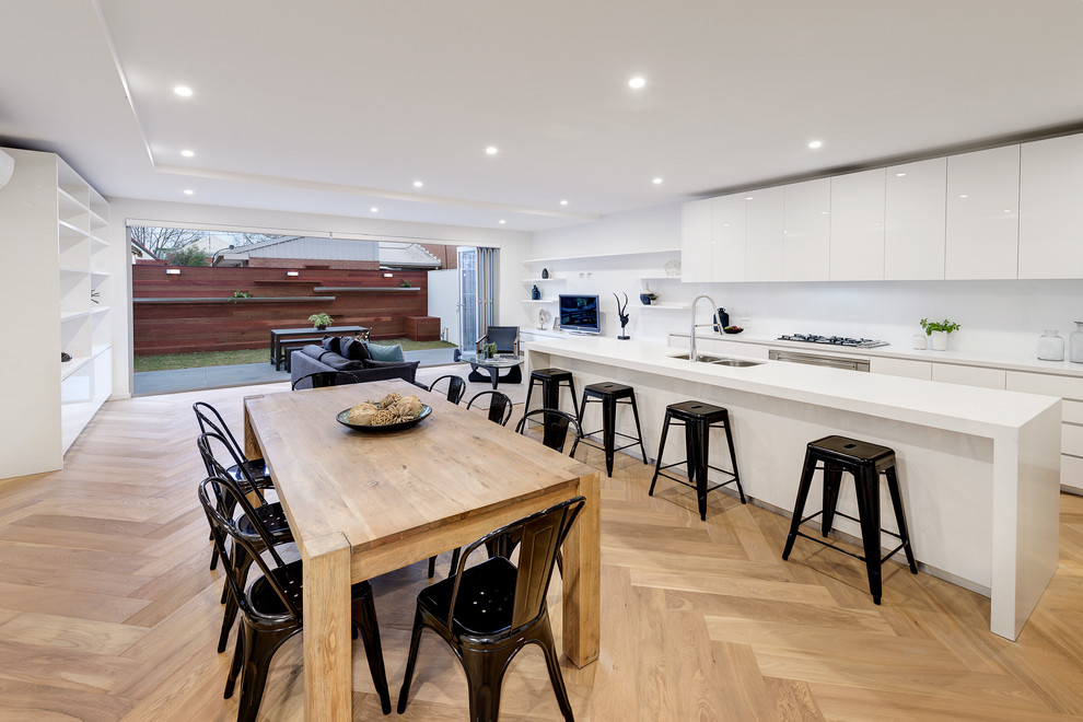 This is an example of a contemporary open plan dining in Melbourne with white walls and light hardwood floors.