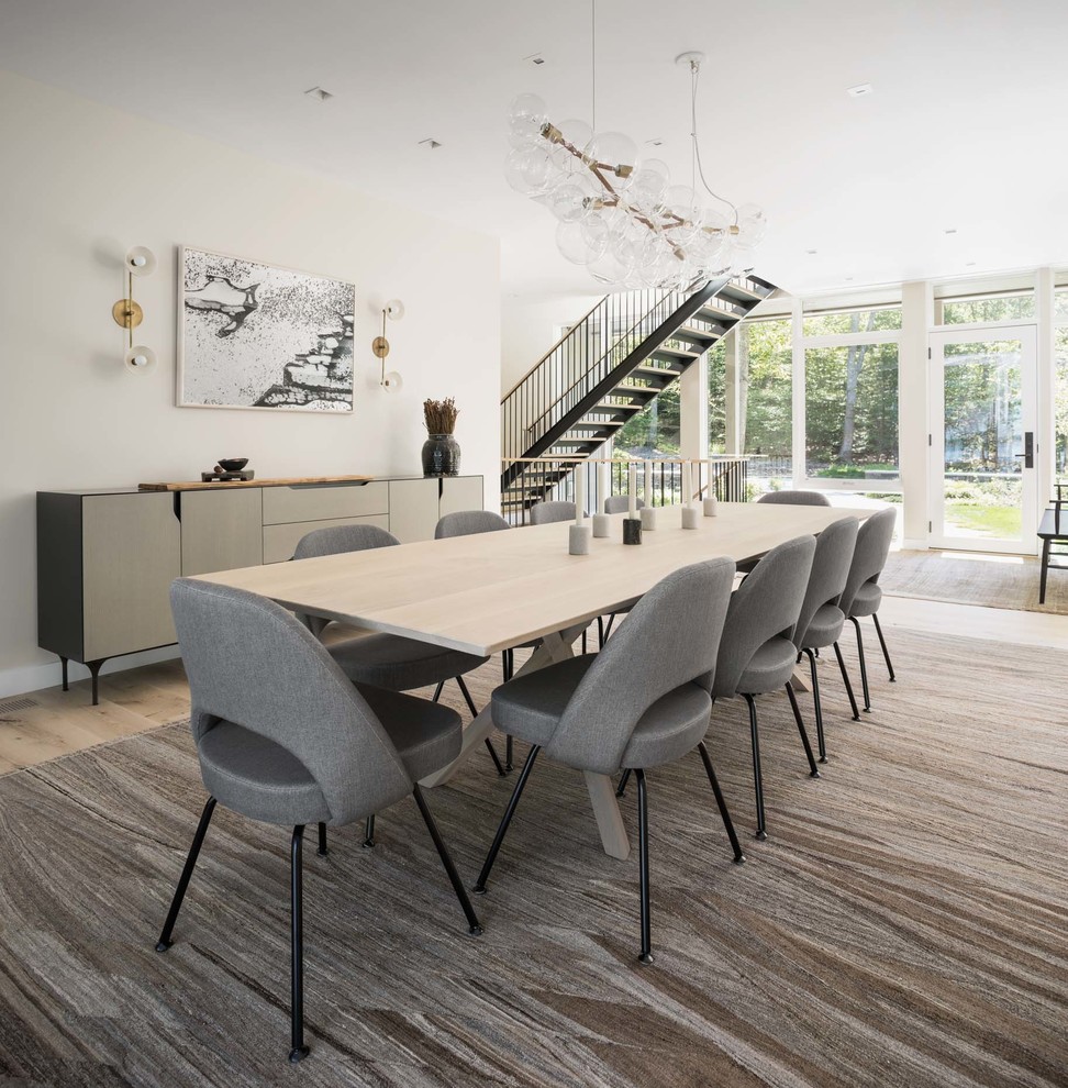 This is an example of a contemporary dining room in Boston with white walls and beige floor.
