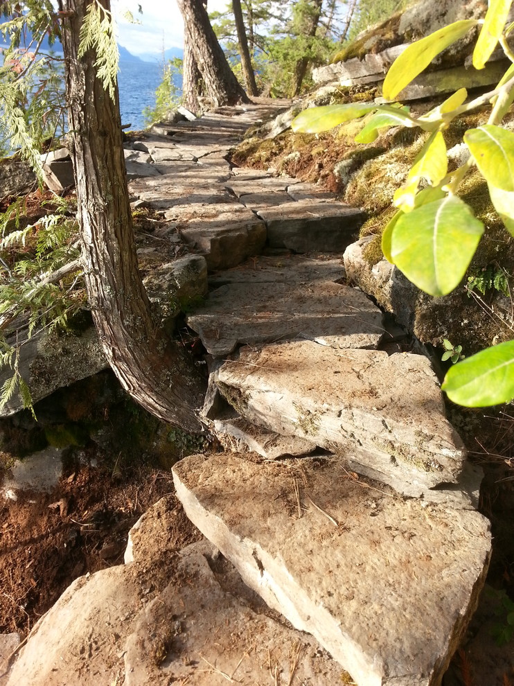 Inspiration for a huge rustic hillside stone garden path for summer.