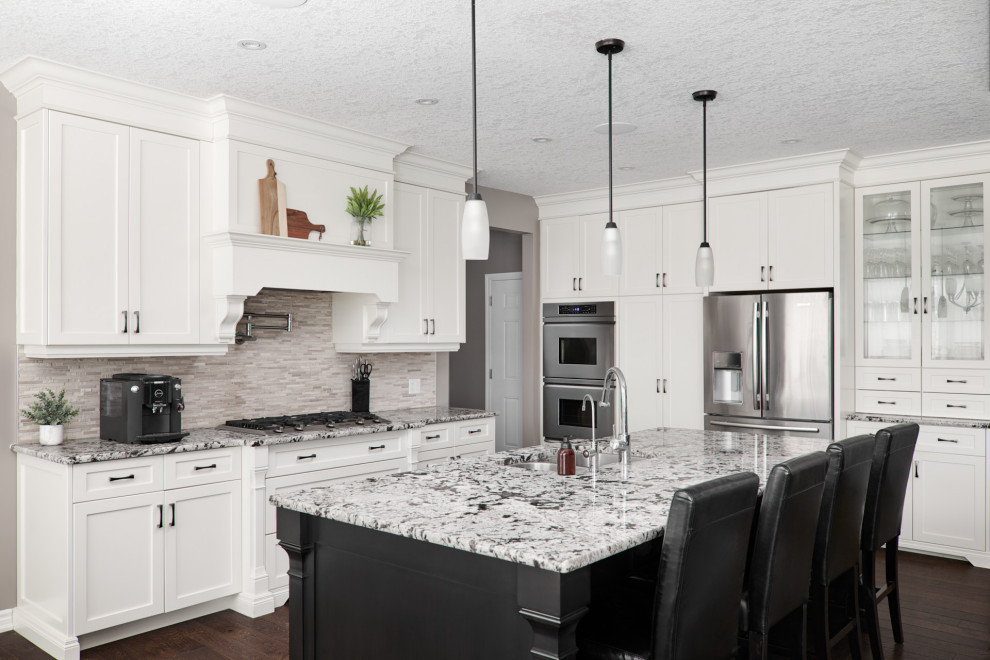Example of a transitional dark wood floor and brown floor open concept kitchen design in Toronto with an undermount sink, shaker cabinets, white cabinets, granite countertops, gray backsplash, stone slab backsplash, stainless steel appliances, an island and gray countertops
