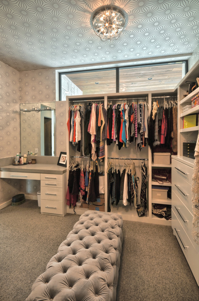 This is an example of a large contemporary women's dressing room in Austin with flat-panel cabinets, white cabinets, carpet and grey floor.