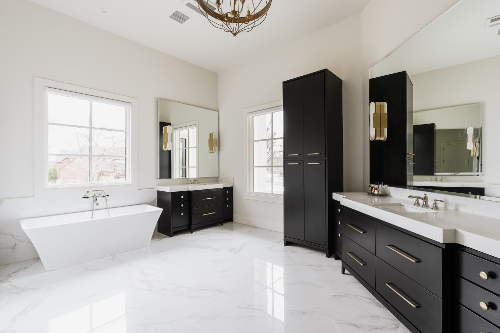 Photo of a large transitional master bathroom in Oklahoma City with furniture-like cabinets, black cabinets, a freestanding tub, a curbless shower, white tile, marble, white walls, engineered quartz benchtops, white floor, white benchtops, a double vanity and a built-in vanity.