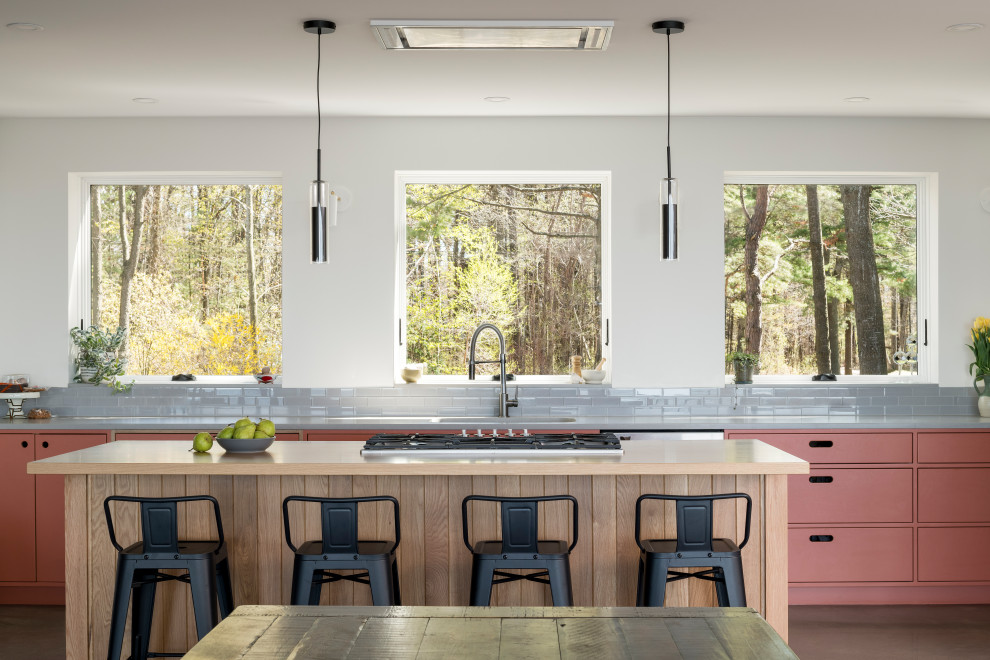 Idéer för att renovera ett stort funkis grå grått kök med öppen planlösning, med en undermonterad diskho, släta luckor, orange skåp, bänkskiva i kvarts, grått stänkskydd, stänkskydd i glaskakel, rostfria vitvaror, betonggolv, en köksö och grått golv