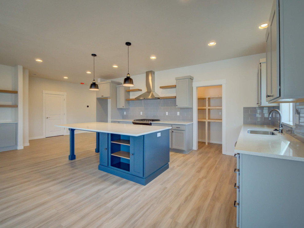 Eat-in kitchen - large transitional l-shaped laminate floor and beige floor eat-in kitchen idea with an undermount sink, shaker cabinets, gray cabinets, quartz countertops, gray backsplash, ceramic backsplash, stainless steel appliances, an island and white countertops