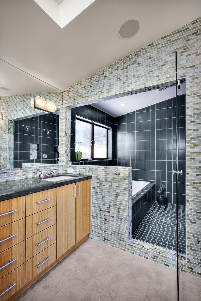 This is an example of a contemporary bathroom in Seattle with an undermount sink, flat-panel cabinets, medium wood cabinets, a drop-in tub, a shower/bathtub combo and multi-coloured tile.