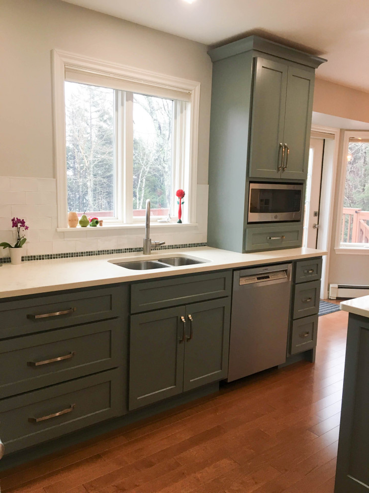 Enclosed kitchen - mid-sized transitional l-shaped medium tone wood floor and brown floor enclosed kitchen idea with a double-bowl sink, shaker cabinets, gray cabinets, quartz countertops, white backsplash, porcelain backsplash, stainless steel appliances, an island and white countertops