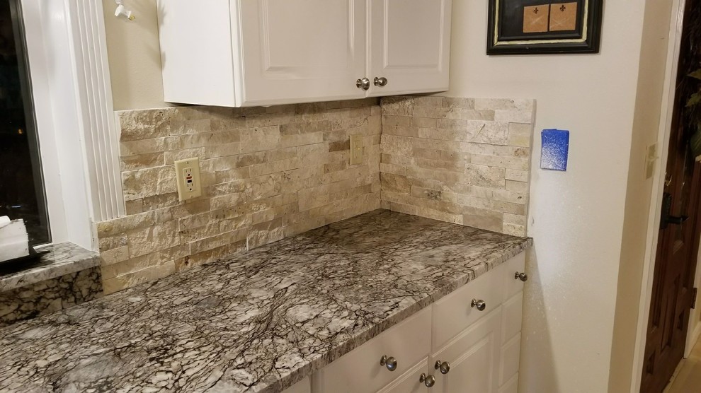 Example of a kitchen design in Seattle with granite countertops and stone tile backsplash