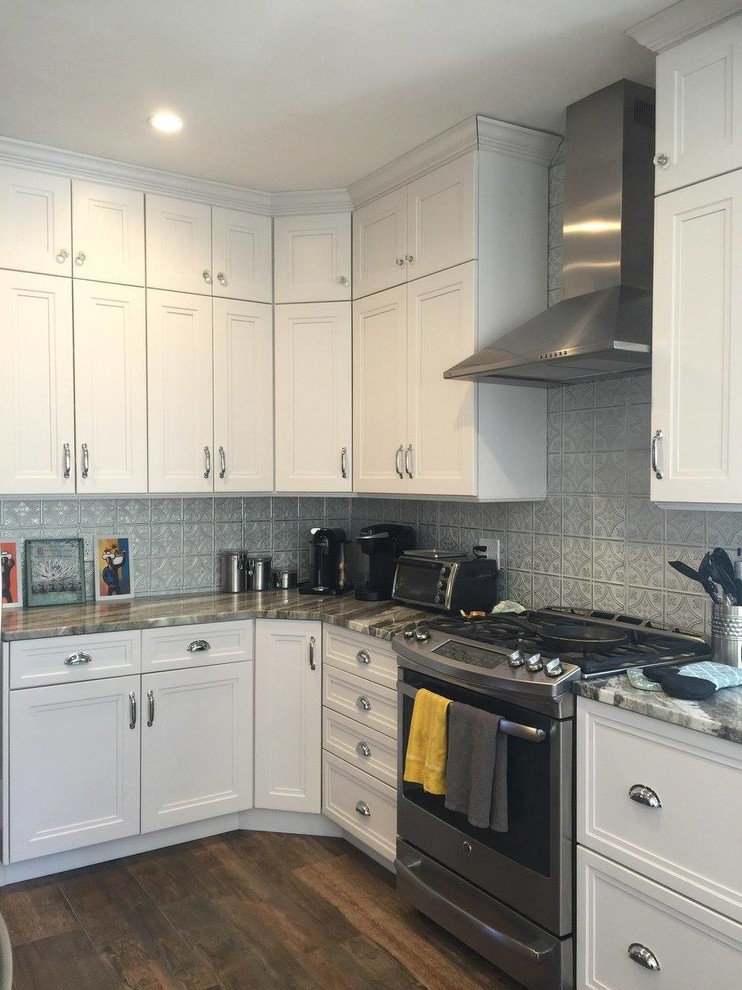 Photo of a mid-sized country u-shaped eat-in kitchen in Boston with a farmhouse sink, shaker cabinets, white cabinets, quartzite benchtops, metallic splashback, metal splashback, stainless steel appliances, ceramic floors and multiple islands.