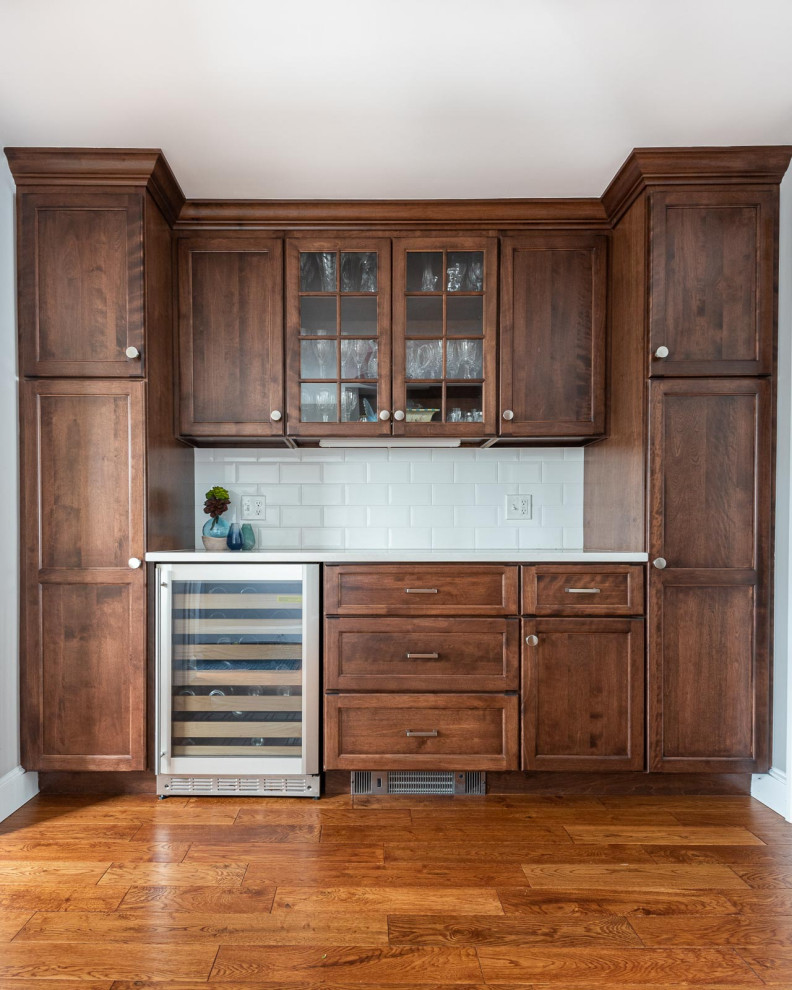 Eat-in kitchen - large transitional l-shaped medium tone wood floor and brown floor eat-in kitchen idea in Boston with an undermount sink, shaker cabinets, white cabinets, quartz countertops, white backsplash, subway tile backsplash, stainless steel appliances, an island and white countertops