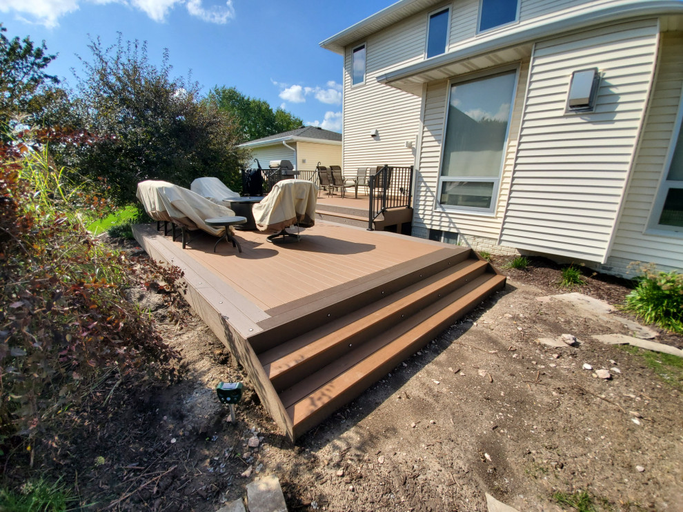 Inspiration for a large backyard ground level metal railing deck remodel with a roof extension