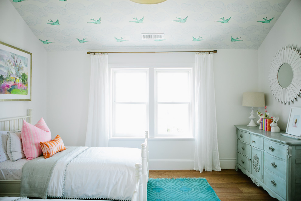 This is an example of a country kids' room for girls in Salt Lake City with white walls and medium hardwood floors.